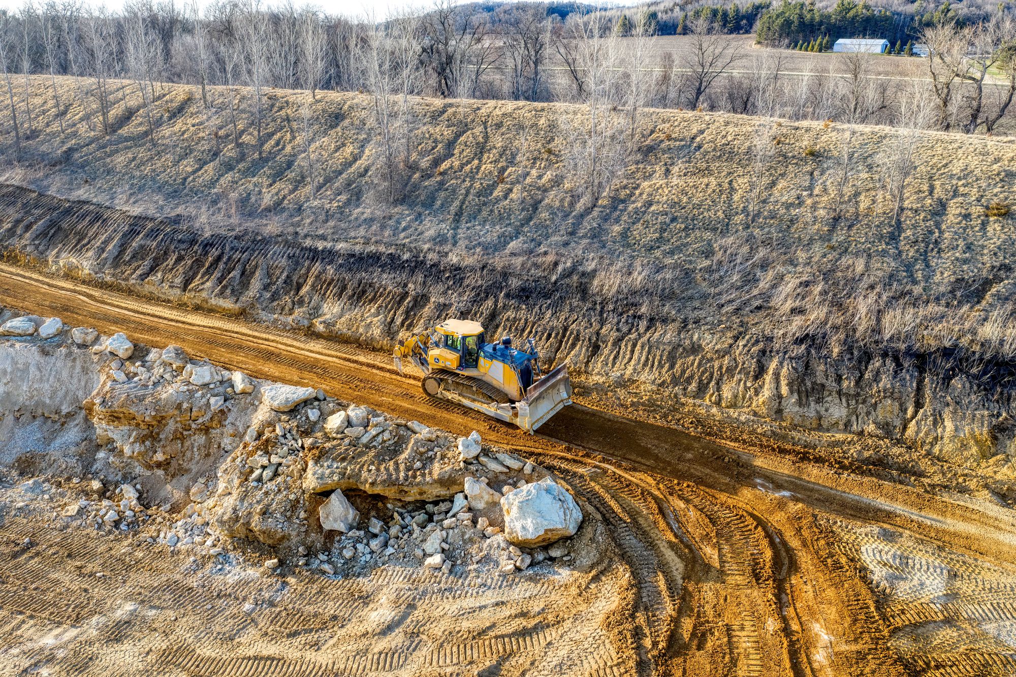 John Deere crawler dozer working on graded ground at a rural site